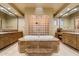 Bright bathroom with a large marble tub, glass block wall, and dual sinks at 6626 E Oberlin Way, Scottsdale, AZ 85266