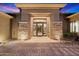 Inviting front entry with custom iron door, stone pillars, and desert landscaping at 6626 E Oberlin Way, Scottsdale, AZ 85266