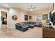 Spacious living room with black leather sectional sofa, tile flooring, ceiling fan and basketball memorabilia at 6626 E Oberlin Way, Scottsdale, AZ 85266