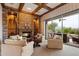 Cozy living room with stone fireplace, wood beam ceiling, and access to the outdoor patio at 6626 E Oberlin Way, Scottsdale, AZ 85266