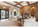 Spacious living room featuring a stone fireplace, wooden beams and ornate entry doors at 6626 E Oberlin Way, Scottsdale, AZ 85266