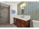 Bathroom featuring a tiled walk-in shower, wood cabinets, and decorative wood paneling at 6934 E Coronado Rd, Scottsdale, AZ 85257