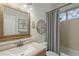 Bathroom featuring a wood-framed mirror, single sink vanity, and shower with neutral tile at 7149 E Quartz St, Mesa, AZ 85207