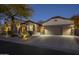 Beautifully lit front exterior with desert landscaping and a two car garage at 7149 E Quartz St, Mesa, AZ 85207