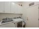 Functional laundry room features two machines, white cabinets, and neutral paint tones at 7149 E Quartz St, Mesa, AZ 85207