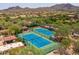 Aerial view of pristine tennis courts nestled within a desert community with mountain views at 7149 E Quartz St, Mesa, AZ 85207