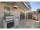 An outdoor patio area featuring a stainless steel grill, access door, and tiled flooring, creating an ideal space for cookouts at 7401 E Northland Dr # 1, Scottsdale, AZ 85251