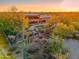 Aerial view of the estate, showcasing the backyard oasis and desert landscape at sunset at 7500 E Roy Rogers Rd, Scottsdale, AZ 85266