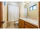 Cozy bathroom featuring a shower-tub combo with tiled surround, and a wood vanity with stone countertop at 7500 E Roy Rogers Rd, Scottsdale, AZ 85266