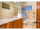 Bathroom with a tiled shower-tub combo, wood cabinets, and marble countertops at 7500 E Roy Rogers Rd, Scottsdale, AZ 85266