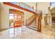 A grand foyer featuring a curved staircase, marble floors, and a custom front door at 7500 E Roy Rogers Rd, Scottsdale, AZ 85266