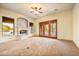 Spacious living room featuring a stone fireplace, double doors to patio, and a ceiling fan at 7500 E Roy Rogers Rd, Scottsdale, AZ 85266