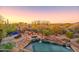 Backyard pool and spa area with desert landscaping and mountain views at dusk at 7500 E Roy Rogers Rd, Scottsdale, AZ 85266