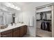 Bathroom featuring a vanity with a sink, large mirror, and closet with hanging storage at 77 W Diamond Trl, San Tan Valley, AZ 85143