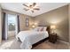 Inviting bedroom with a comfortable bed, ceiling fan, and natural light from the window at 77 W Diamond Trl, San Tan Valley, AZ 85143