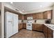 Functional kitchen with white appliances, wood cabinets, and lots of space at 77 W Diamond Trl, San Tan Valley, AZ 85143