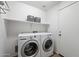 Clean laundry room with new washer and dryer, storage shelf, and a convenient layout at 77 W Diamond Trl, San Tan Valley, AZ 85143