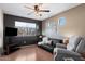 Cozy living room with dark accent wall, ceiling fan, and comfortable seating at 77 W Diamond Trl, San Tan Valley, AZ 85143