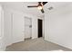 This bedroom offers neutral carpeting, a ceiling fan, and a closet with sliding doors at 781 W Flintlock Way, Chandler, AZ 85286