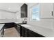 Close-up of sleek kitchen featuring white countertops and dark lower cabinets with modern fixtures at 781 W Flintlock Way, Chandler, AZ 85286