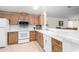 Bright kitchen area with white appliances, light wood cabinetry, and tiled flooring at 8500 E Southern Ave # 488, Mesa, AZ 85209