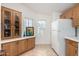 Kitchen featuring wood cabinetry, tiled floors, an adjacent refrigerator, and ample counter space at 8500 E Southern Ave # 488, Mesa, AZ 85209