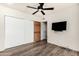 Clean bedroom with hardwood floors, a ceiling fan, and closet space at 8502 E Cave Creek Rd # 53, Carefree, AZ 85377