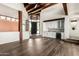 Bright living room featuring exposed beam ceilings, a bar area, and rich hardwood flooring at 8502 E Cave Creek Rd # 53, Carefree, AZ 85377
