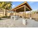 Outdoor kitchen area featuring a stone bar, built-in grill, and tiled patio at 8630 W Apache St, Tolleson, AZ 85353