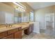 Bathroom with dual sinks, vanity space, large mirror and shower at 8634 E Kael Cir, Mesa, AZ 85207