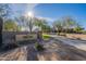 Stone sign for Mountain Bridge Owners Club with desert landscaping, mature trees, and a glimpse of the community building at 8634 E Kael Cir, Mesa, AZ 85207