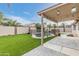 Landscaped backyard featuring a covered patio, artificial grass, a stone tiled outdoor rug, and a fenced in pool at 9001 W Lone Cactus Dr, Peoria, AZ 85382