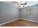 Bedroom with laminate wood floors, ceiling fan and large window with blinds at 9544 E Irwin Ave, Mesa, AZ 85209