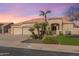 Inviting single-story home featuring a three-car garage, well-manicured lawn, desert landscaping, and a tile roof at 9544 E Irwin Ave, Mesa, AZ 85209