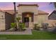 Warm and welcoming front entrance featuring a charming covered porch, desert landscaping, and a wood door at 9544 E Irwin Ave, Mesa, AZ 85209