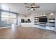 Open living room featuring a stone accent wall, tile flooring, and a ceiling fan at 9544 E Irwin Ave, Mesa, AZ 85209