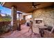 Cozy outdoor patio with a stone fireplace, grill, and desert views at 10112 E Old Trail Rd, Scottsdale, AZ 85262