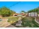 Expansive backyard featuring lush lawn, relaxing lounge area, and convenient storage shed at 9388 W Cashman Dr, Peoria, AZ 85383