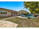 Expansive backyard featuring a sparkling pool with a rock waterfall, lush landscaping, and a covered patio at 9388 W Cashman Dr, Peoria, AZ 85383