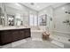 A luxurious bathroom featuring a soaking tub, double vanity, and a glass-enclosed walk-in shower at 9388 W Cashman Dr, Peoria, AZ 85383