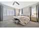 Bright bedroom with a tufted headboard, soft textures, and large windows with shutter style shades at 9388 W Cashman Dr, Peoria, AZ 85383