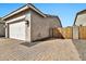 Charming home exterior with a two-car garage, brick driveway, and decorative accents at 9388 W Cashman Dr, Peoria, AZ 85383