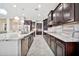 Spacious kitchen featuring dark wood cabinets, and a large granite countertop island with breakfast bar at 9388 W Cashman Dr, Peoria, AZ 85383