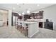 Well-appointed kitchen with dark wood cabinets, stainless steel appliances, and a large island with barstool seating at 9388 W Cashman Dr, Peoria, AZ 85383