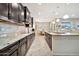 Kitchen featuring dark wood cabinets, stainless steel appliances, granite counters, and views to the dining area at 9388 W Cashman Dr, Peoria, AZ 85383