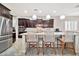 Bright and airy kitchen featuring dark wood cabinets, a marble backsplash, stainless appliances, and a breakfast bar at 9388 W Cashman Dr, Peoria, AZ 85383