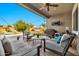 Inviting covered patio with comfortable seating, ceiling fan, outdoor TV, and a view of the sparkling pool at 9388 W Cashman Dr, Peoria, AZ 85383