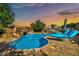 Backyard features a beautiful pool with waterfall, lounge chairs, and mature trees at 9388 W Cashman Dr, Peoria, AZ 85383