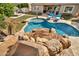 Backyard pool featuring rock waterfall and slide, with beautiful lounge chairs for relaxing by the pool at 9388 W Cashman Dr, Peoria, AZ 85383