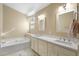 Well-lit bathroom with a soaking tub, dual sinks and vanity providing a spa-like feel at 10622 W Mohawk Ln, Peoria, AZ 85382